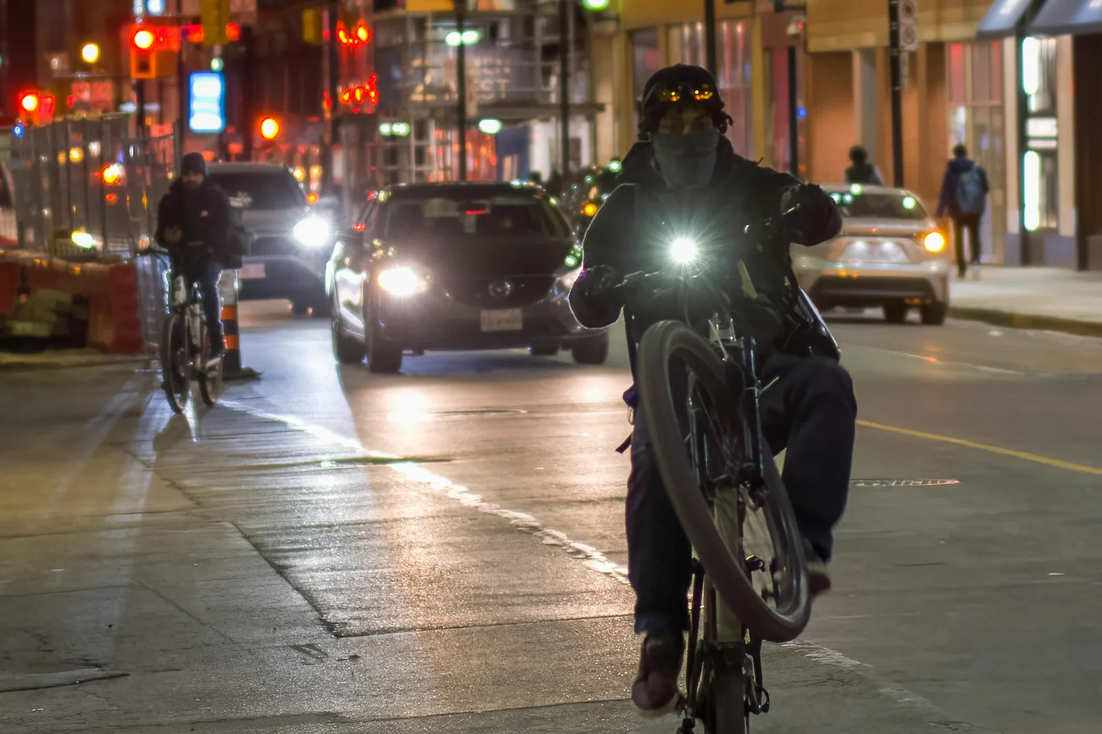 Ciclista urbano de noche con luz frontal visible
